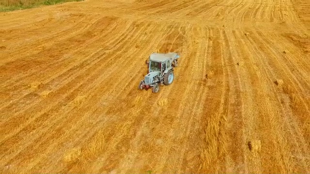 拖拉机打包机穿过黄色茬地视频素材