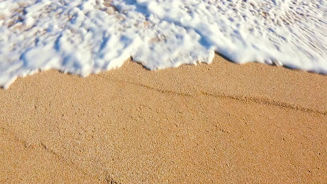 海浪卷起白色沙滩的特写。视频素材