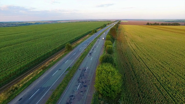 在夕阳下飞过田野间的公路视频素材