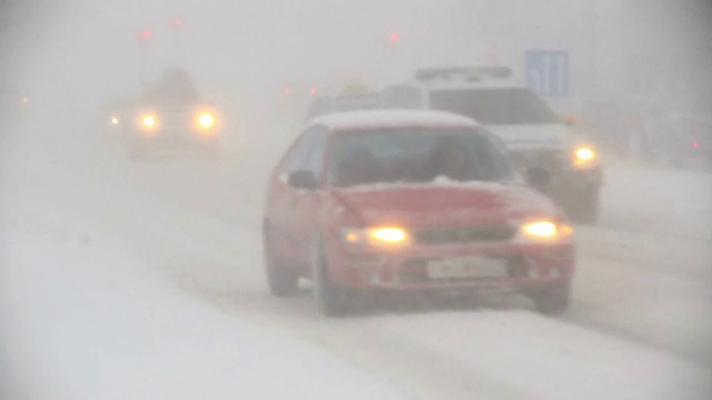 在冰岛的雷克雅未克，在暴风雪中车灯闪烁，能见度为零视频素材