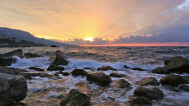 日出和海浪拍打石头的景观视频素材