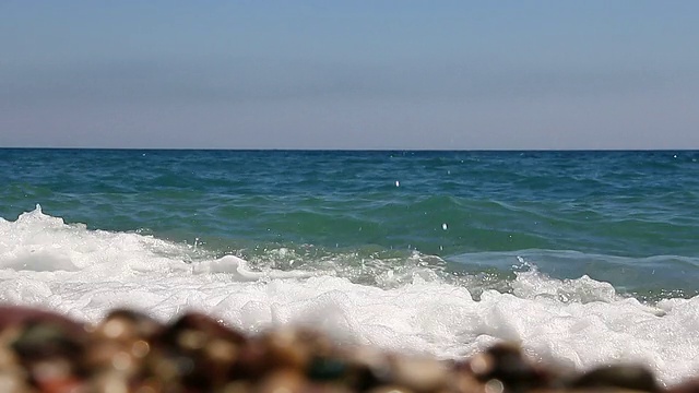 海浪的背景在美丽的卵石海滩上。视频素材