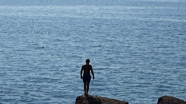 一个人从悬崖上跳进海里视频素材