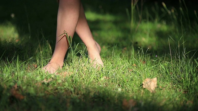 穿着淡雅夏装的女孩在阳光明媚的户外走在田野里视频素材