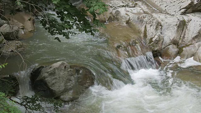 湍急的山涧流过大岩石。视频素材