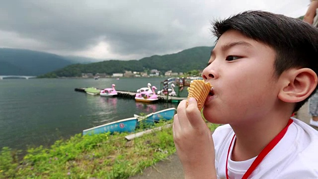 年轻的亚洲男孩在吃冰淇淋视频素材