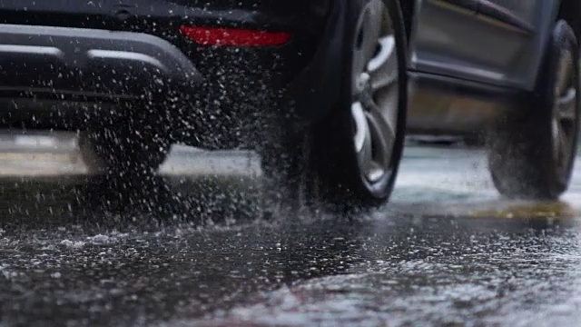 雨天的城市街道，水滴，水坑，汽车经过，超慢的动作，选择性聚焦。视频素材