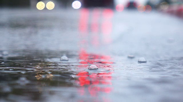 雨天的城市街道，水滴，水坑，汽车经过，超慢的动作，选择性聚焦。视频素材