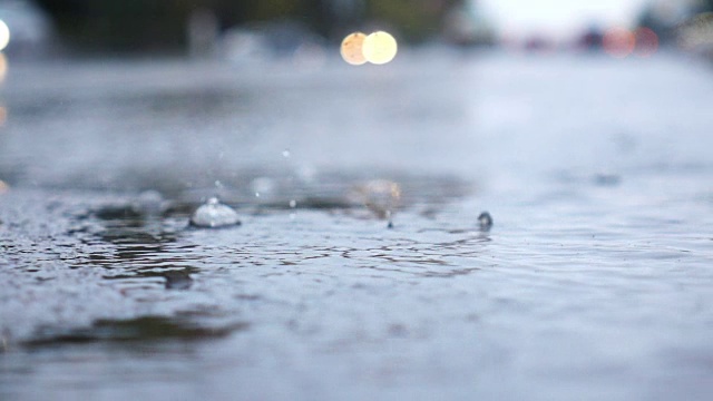 雨天的城市街道，水滴，水坑，汽车经过，超慢的动作，选择性聚焦。视频素材