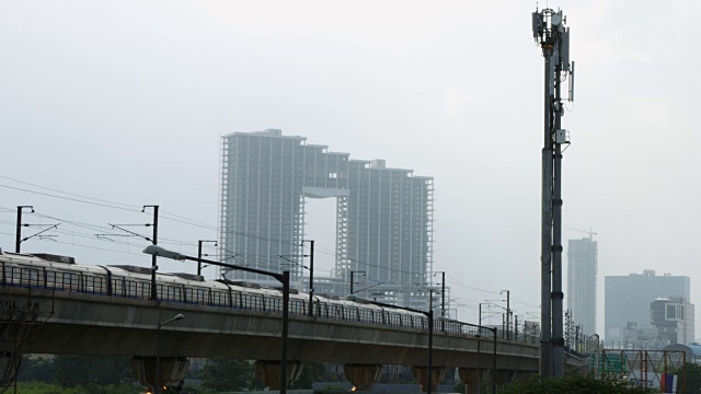 新德里，印度，地铁列车在摩天大楼前移动的锁定镜头视频素材