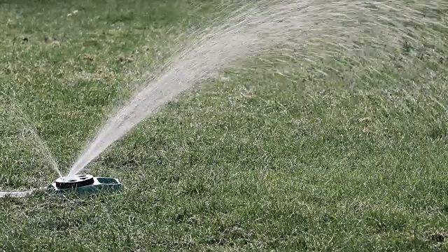 浇绿草坪的洒水车视频素材