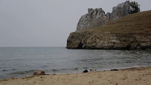 多云的天在空海海滩沙滩和海浪，潮汐的海浪打破了野生海滩上的天然悬崖跳跃视频素材