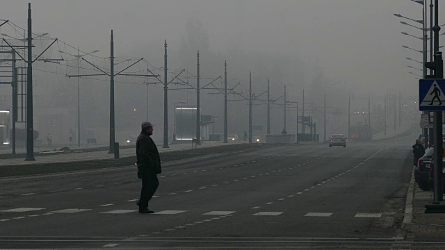 人在薄雾清晨穿过宽阔的公路视频素材