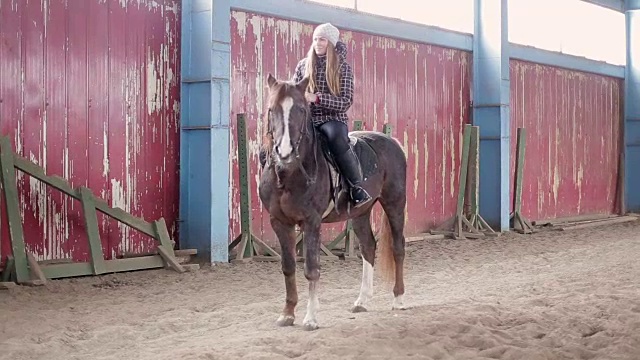 年轻女子在马厩里骑马视频素材