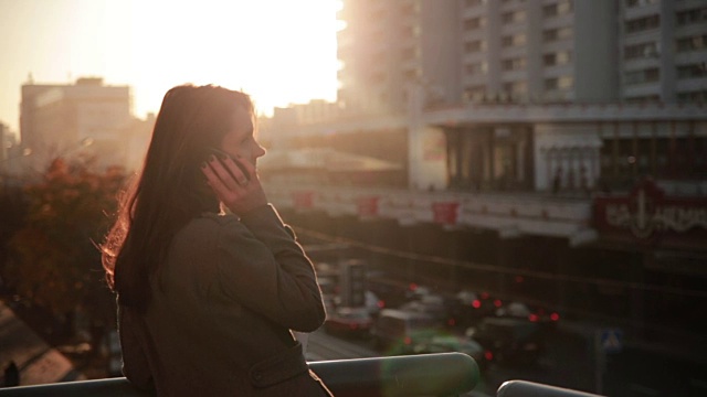 一个在城市桥上打电话的漂亮女人视频素材