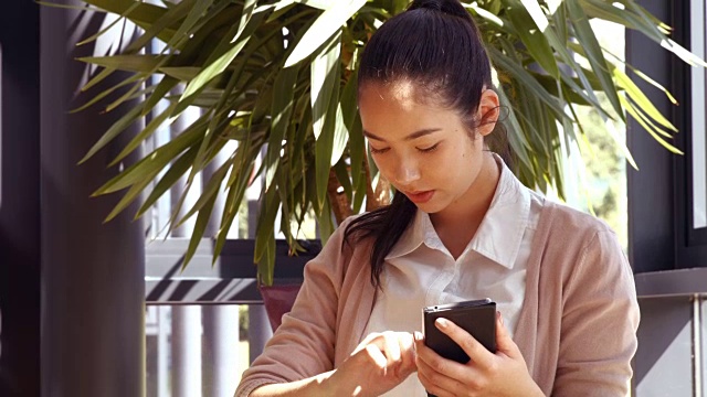 亚洲女商人用她的电话视频素材