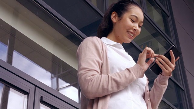 亚洲女商人在外面用手机视频素材