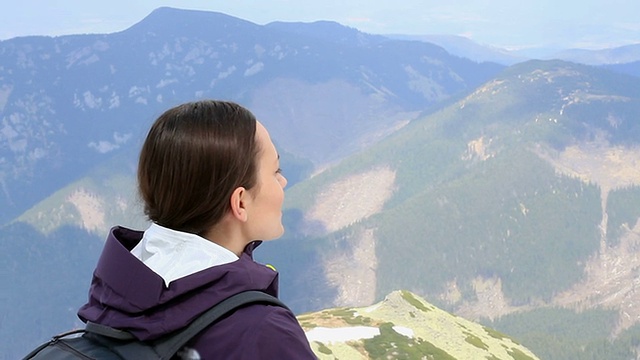 年轻女游客欣赏山谷景色，稳定器拍摄视频素材