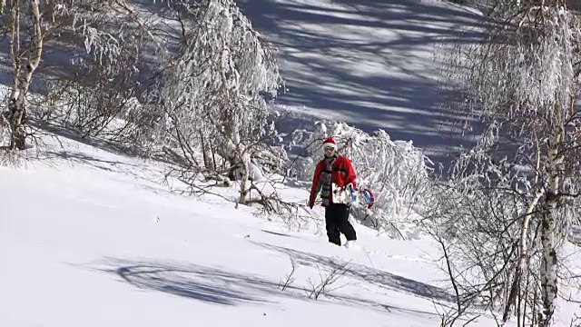 在山腰上走着滑雪板的男人视频下载