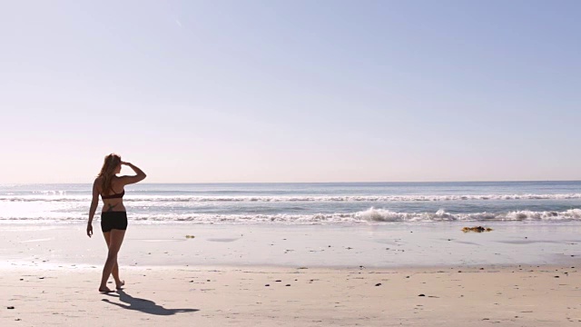 海滩上的女人朝大海走去视频素材