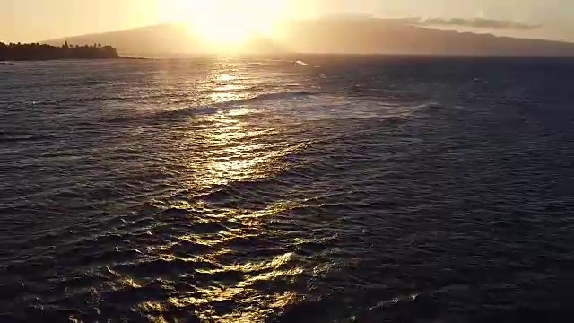 在日落的海浪上飞行。令人惊叹的日落空中海景视频下载