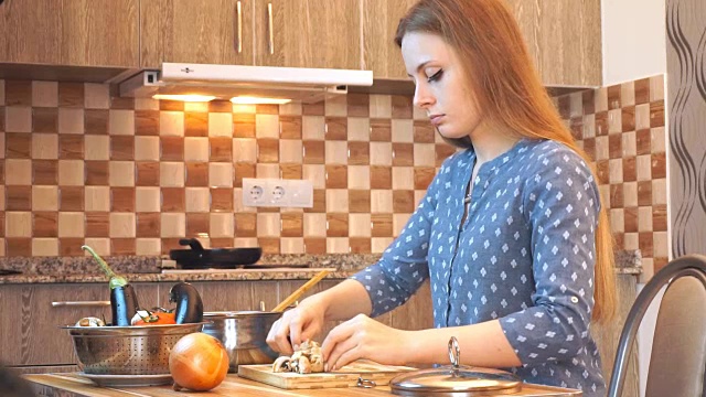 健康饮食生活方式:漂亮女人随便做饭，在厨房切菜。中景，手持，慢镜头60帧/秒。视频素材