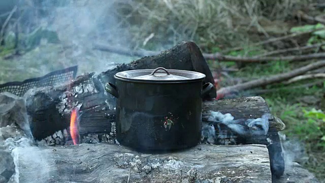 传统烹饪——用柴火加热金属锅视频素材