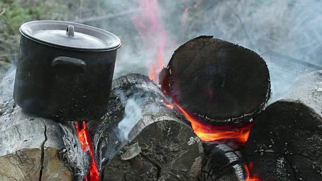 传统烹饪——用柴火加热金属锅视频素材