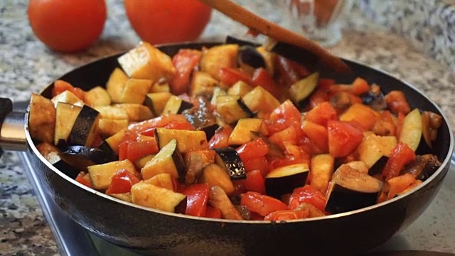 健康饮食生活方式:漂亮女人随便做饭，炒菜，在厨房的锅里炖蔬菜。特写镜头,手持。视频素材