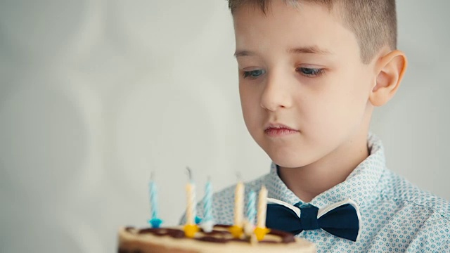 小男孩吹灭生日蛋糕上的蜡烛视频素材