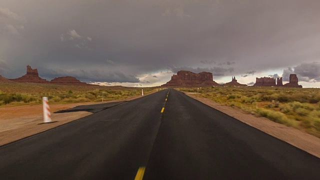 驾驶美国:在一个孤独的沙漠道路上驾驶的观点，纪念碑谷视频素材