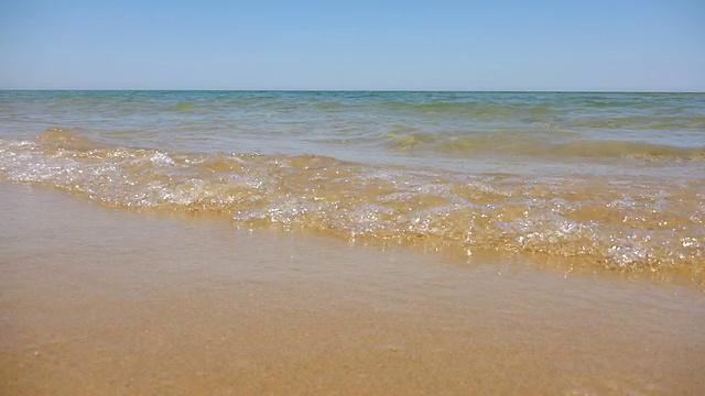 阳光明媚的夏日，海浪拍打着海滩视频下载