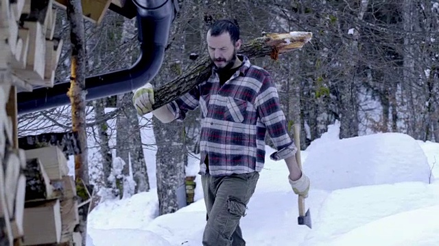 带着一根圆木在雪地里走的人视频素材