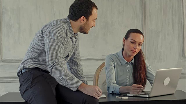 在办公室里用笔记本电脑的严肃的商人和女人视频素材