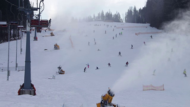 滑雪者在滑雪场和雪炮上滑行视频素材