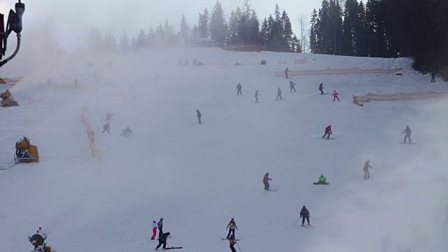 滑雪者在滑雪场和雪炮上滑行视频素材