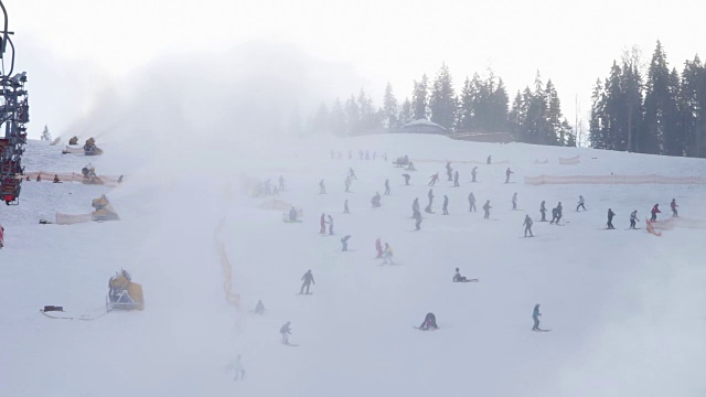 滑雪者在滑雪场和雪炮上滑行视频素材