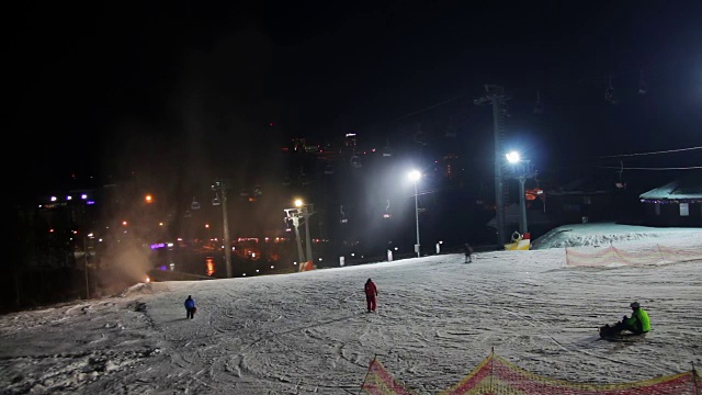 滑雪者在滑雪场和雪炮上滑行视频素材