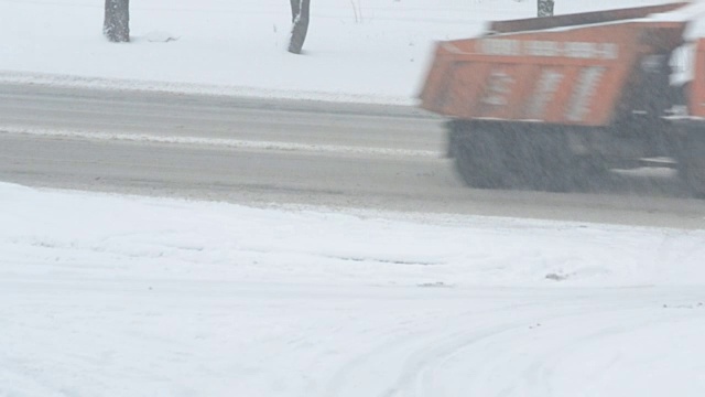 在冬天，汽车在被雪覆盖的路上行驶视频素材