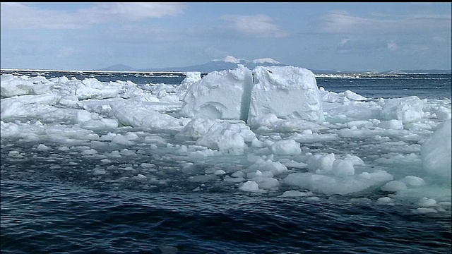 北海道知床，鄂霍次克海浮冰留下的痕迹，背景是白雪覆盖的山脉视频素材