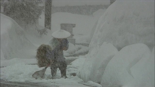 日本秋田横田，一名男子在大雪中从大雪堆中铲雪视频素材