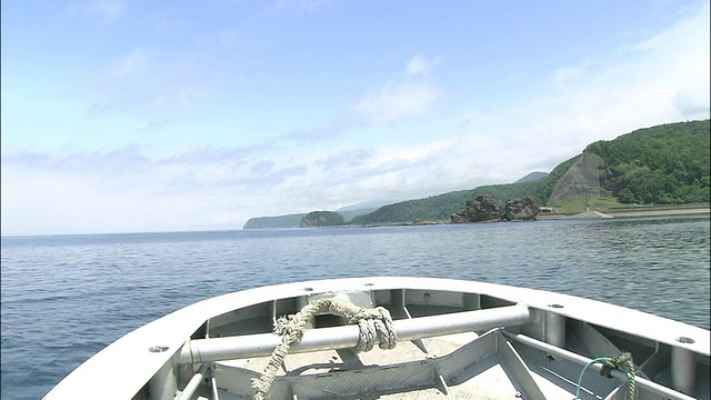 沿鄂霍次克海航行的船只沿北海道鄂霍次克海的知床半岛海岸线前进视频素材