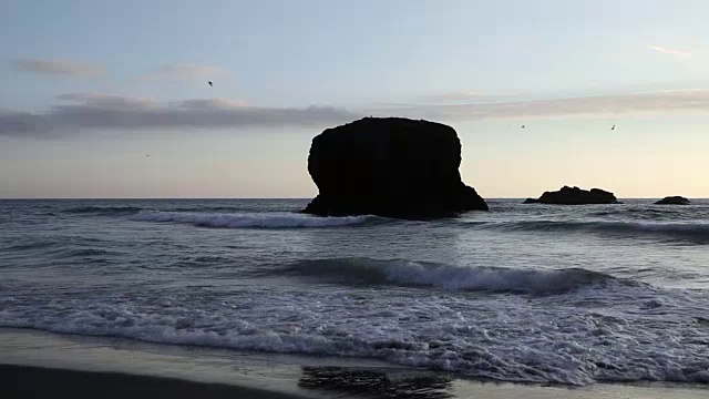 岸边岩石的剪影与海浪视频素材