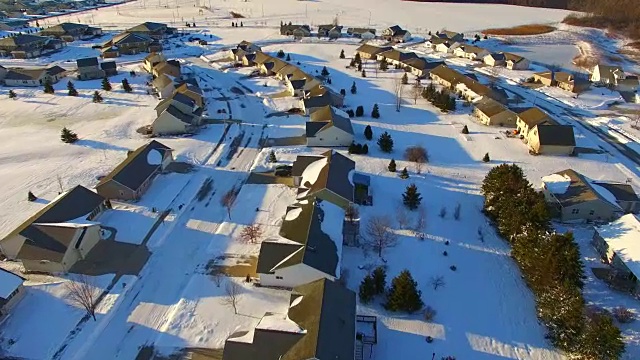 清晨空中巡视积雪覆盖的社区和郊区的房屋视频素材