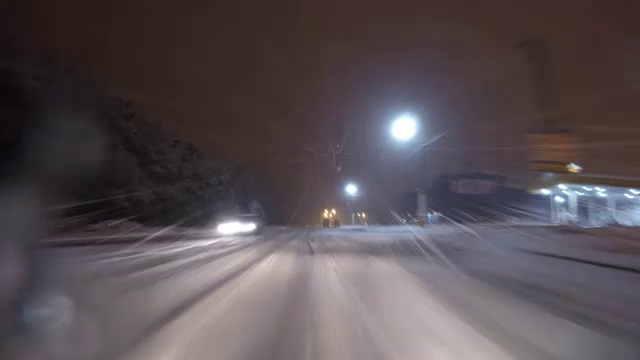 冬天下雪时，汽车在夜间城市道路上行驶视频素材