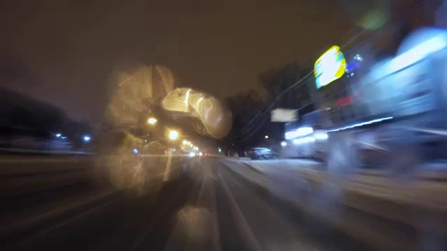 冬天下雪时，汽车在夜间城市道路上行驶视频素材