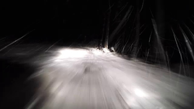 下雪了。晚上在雪地上快速行驶的汽车视频素材