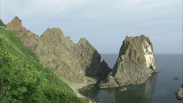 在岩石密布的海岸上，小船在浅滩上聚集海胆视频素材