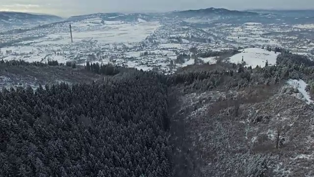 鸟瞰图的森林山丘和乡村村庄在冬天视频素材