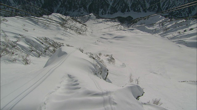 在日本，一颗耀眼的白色太阳照耀着白雪覆盖的山。视频素材